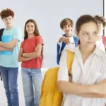 outcast-teenager-girl-suffering-bullying-school-group-classmates-laughing-behind-sad-female-standing-alone-her-331936089